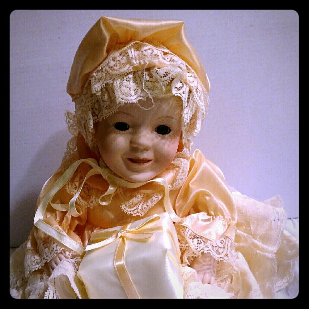 9" Sitting Doll w/ present dressed in peach outft